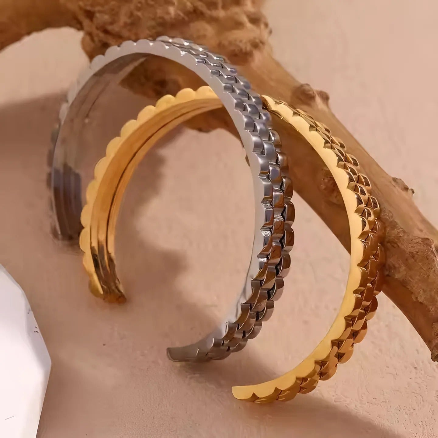 Model draagt een glanzende gouden armband, die klassieke gratie belichaamt