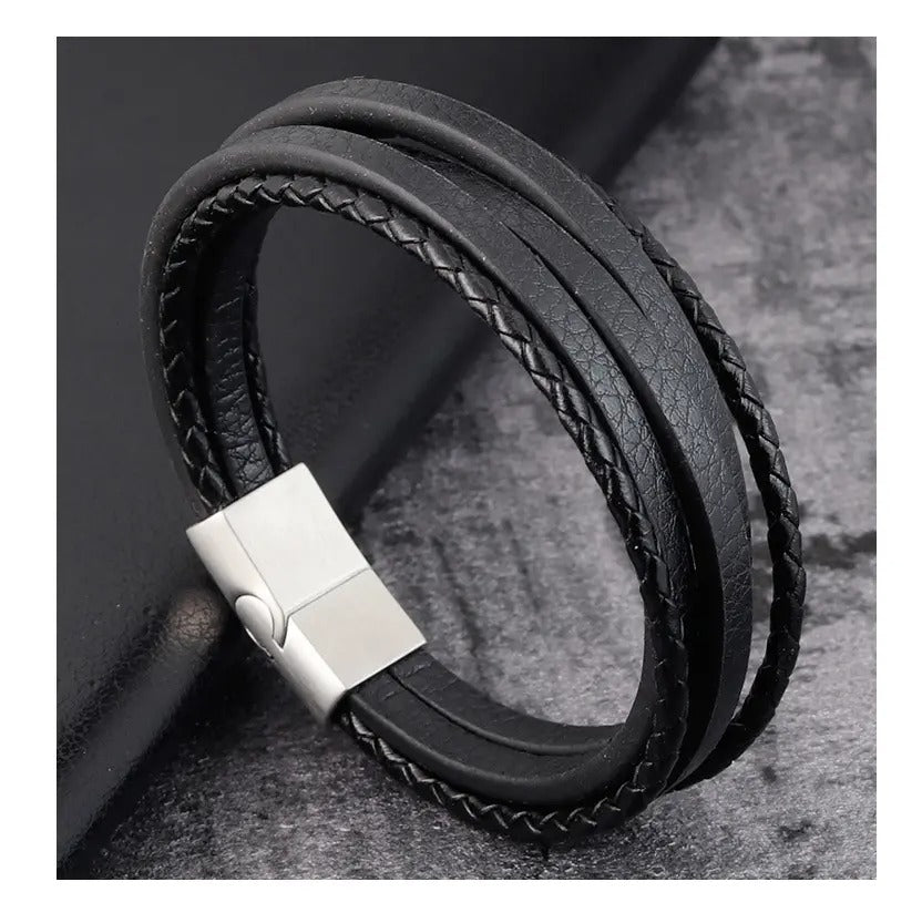 Close-up van een zwarte leren armband met een op maat gegraveerde sluiting, die tijdloze verfijning uitstraalt.