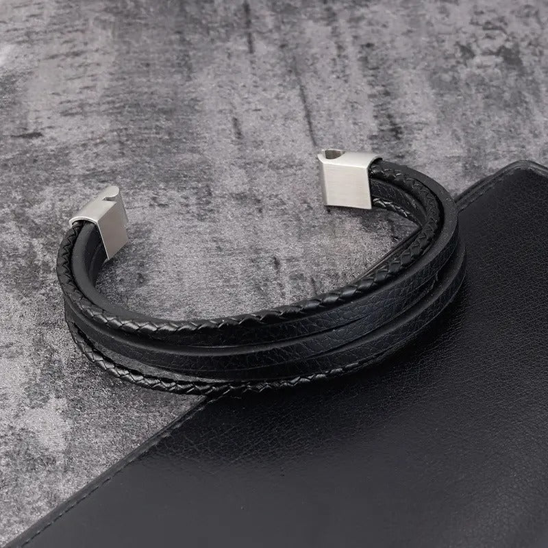 Model draagt een verfijnde leren armband met een naam-gegraveerde sluiting, die unieke stijl belichaamt.