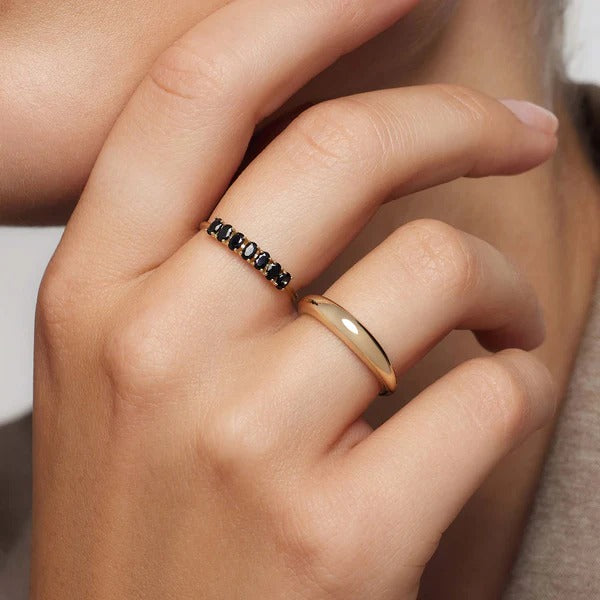 Elegant gouden ring met edelsteen en een rij zwarte spinelstenen