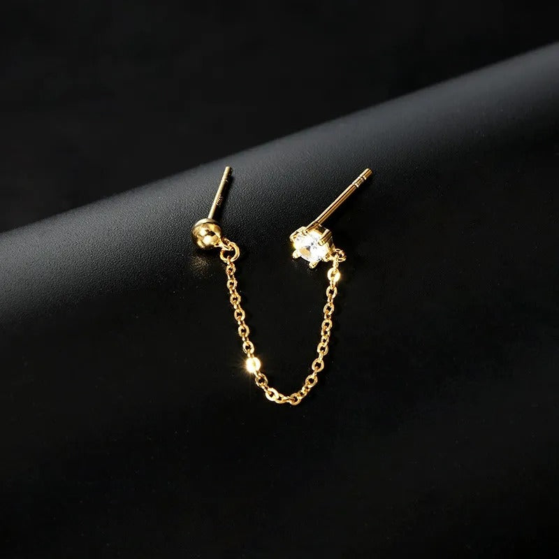 Een glinsterende gouden ketting overbrugt het oorlelletje en de helix, een delicate aanraking van elegantie