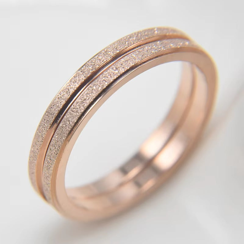 Deze eigentijdse ring presenteert een rosegoud vergulde band met afwisselend matte en glanzende secties, wat verfijnde stijl belichaamt