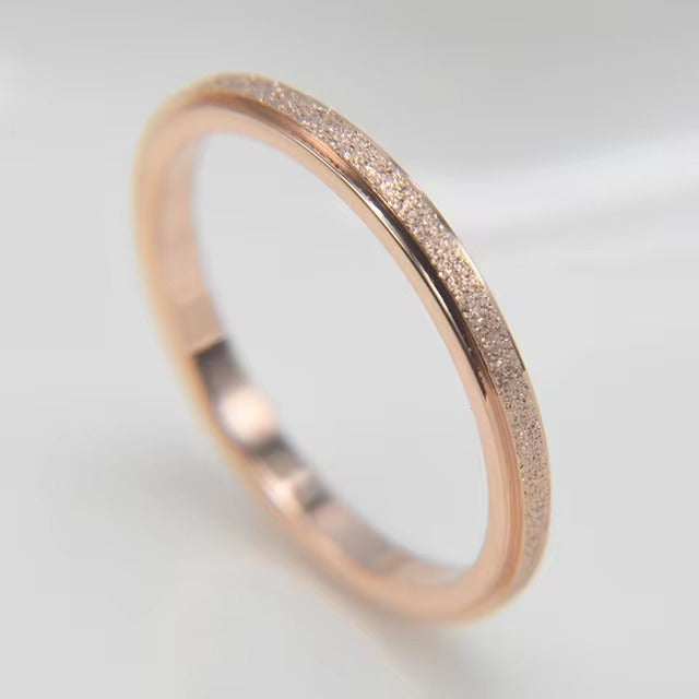 Een minimalistische rosegouden ring met contrasterende texturen—mat en glanzend—biedt een unieke en elegante uitstraling