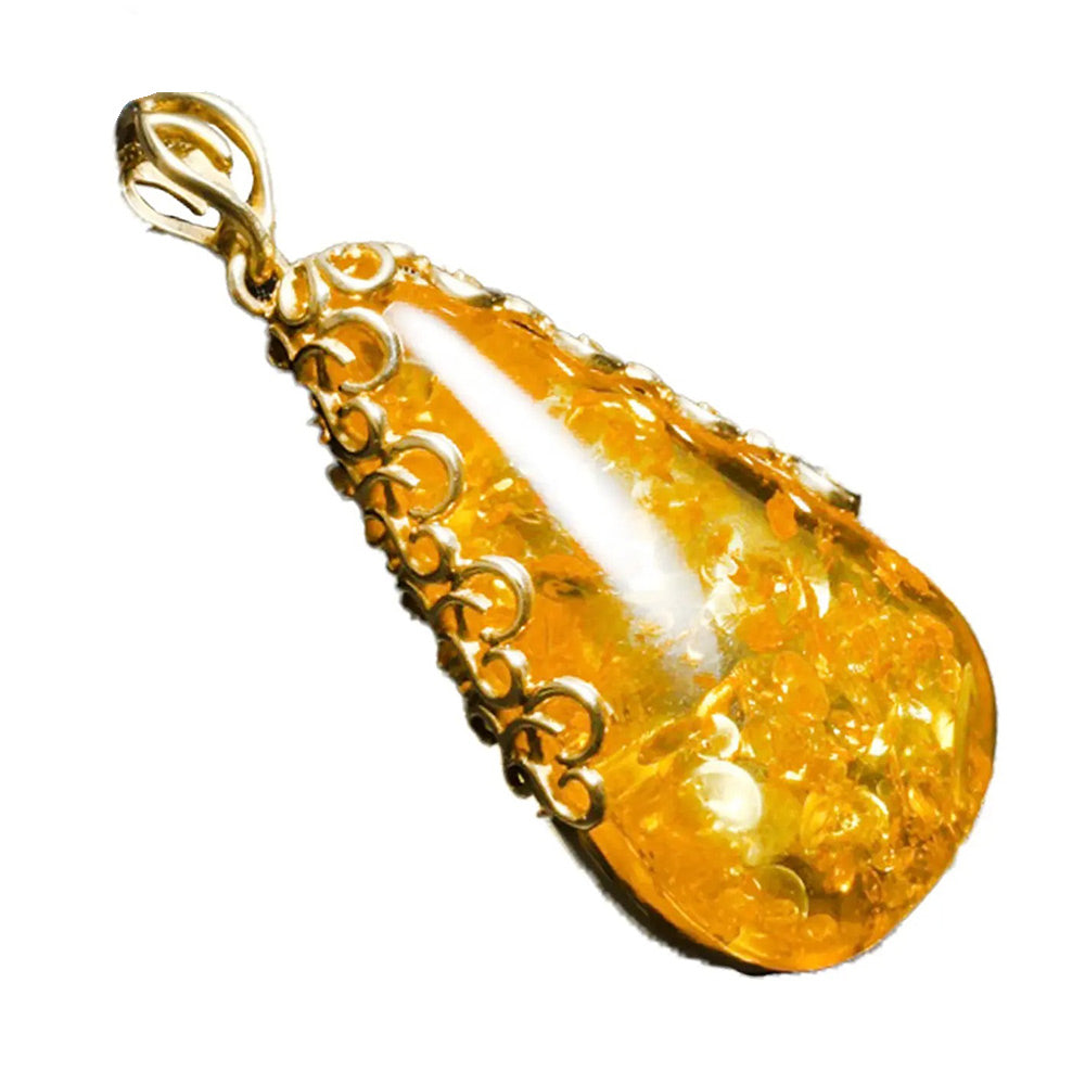 Gouden barnstenen hanger, een druppel zonlicht vastgehouden door de zachte greep van geel goud