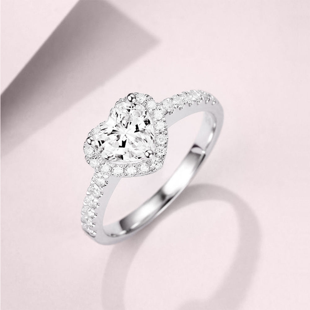 Een glanzende zilveren ring met een hart als middelpunt, versierd met sprankelende zirconia, die tijdloze romantiek belichaamt
