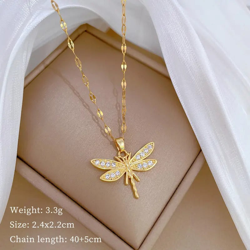 Een stralend libelle-bedeltje in goud, waarvan de met zirconia bezaaide vleugels licht weerkaatsen als ochtenddauw op een weide