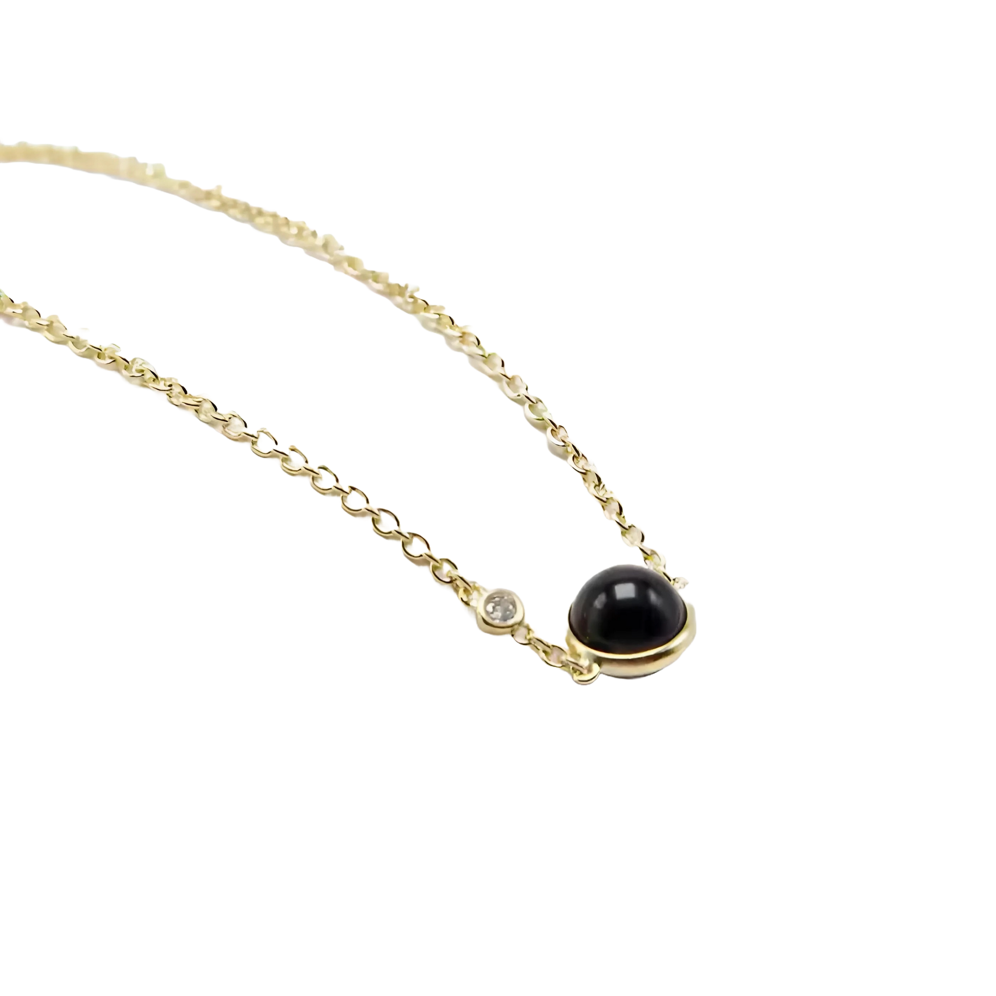 Elegante vergulde armband met een glanzende zwarte agaatsteen, die diepe aantrekkingskracht weerspiegelt