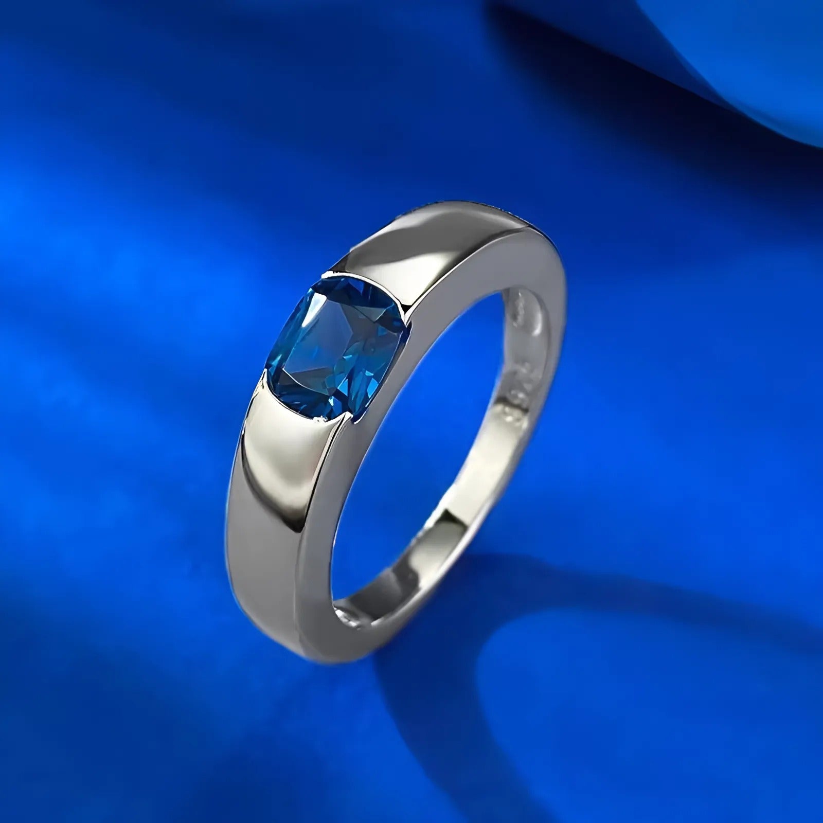Deze handgemaakte witgouden ring bevat een ovaalgeslepen saffier, omringd door een delicate reeks sprankelende diamanten