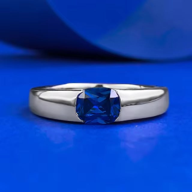 Een glanzende witgouden band toont een centrale saffier, omarmd door een constellatie van stralende diamanten