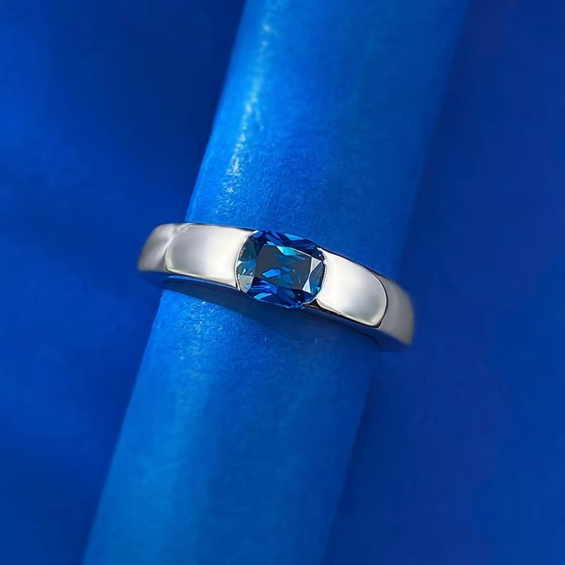 In deze elegante ring rust een levendige saffier in het hart, omringd door een lumineuze halo van briljantgeslepen diamanten