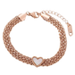 Model draagt een zilveren armband met glinsterende details en een open hart bedel, die gracieuze verfijning belichaamt