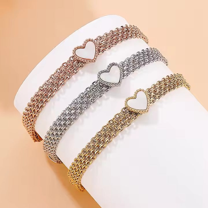 Gepolijste zilveren armband met lumineuze versieringen en een open hart als focuspunt, die blijvende liefde symboliseert