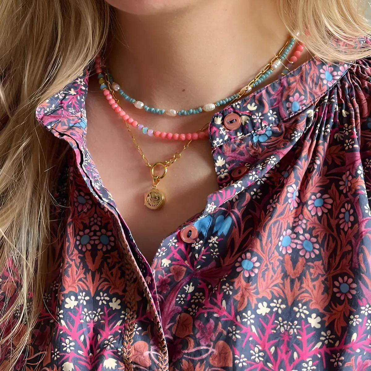 Delicate gouden ketting met een voorwaartse sluiting en een klein rond medaillon, ideaal voor alledaagse elegantie.