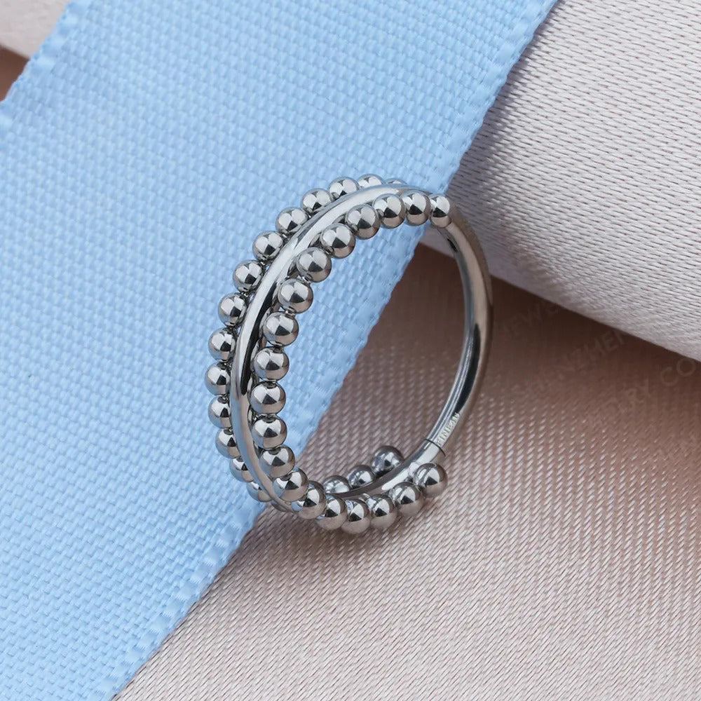 Een zilveren helix-ring met getextureerde kralen, straalt een rustieke maar moderne bohemian geest uit